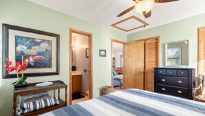 A bedroom with a bed, a dresser, a nightstand, a framed painting, and a ceiling fan. - Kiki's Retreat: Walk to Duck Village | Pets OK (Duck)