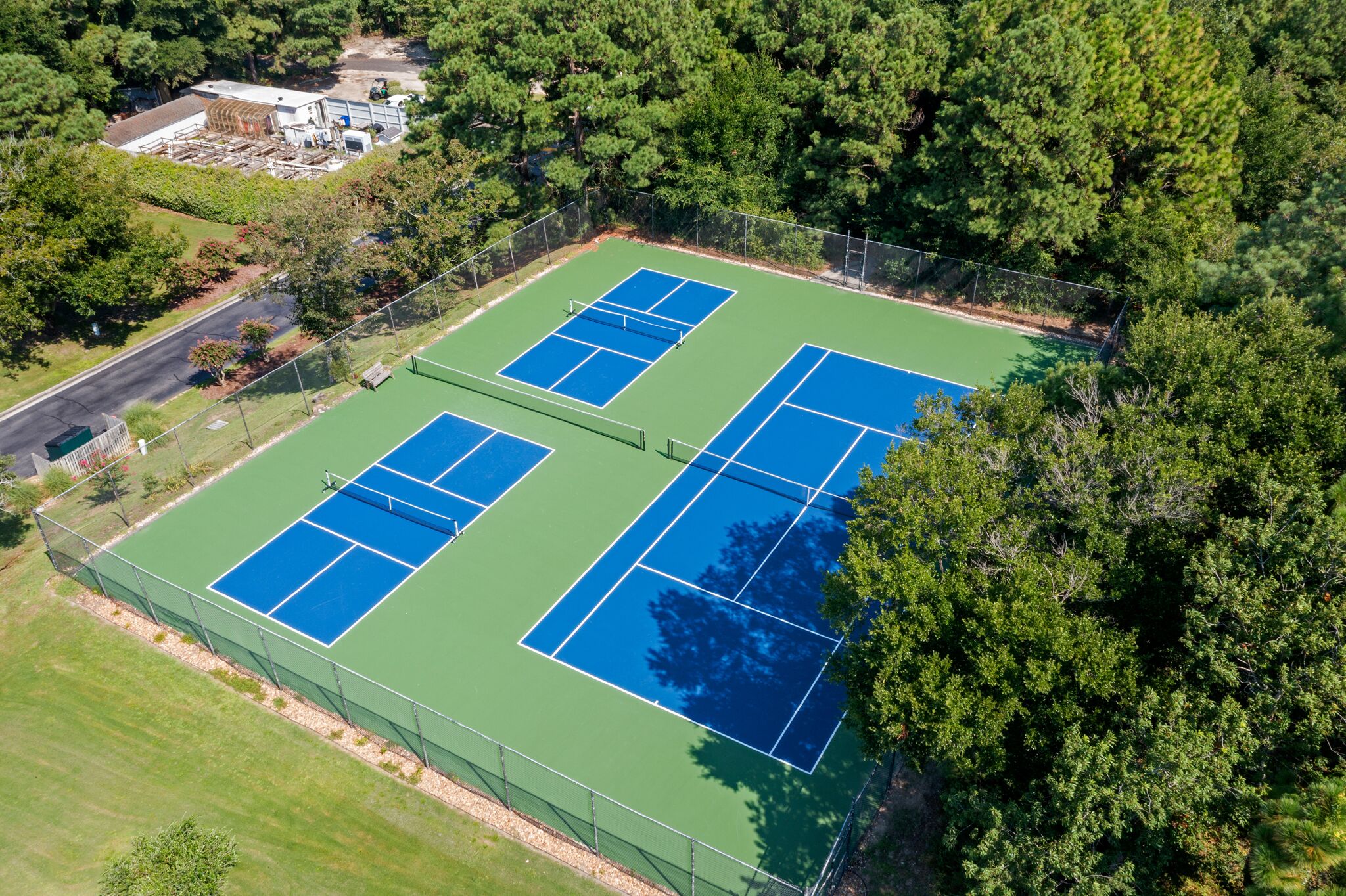 A tennis court surrounded by trees.