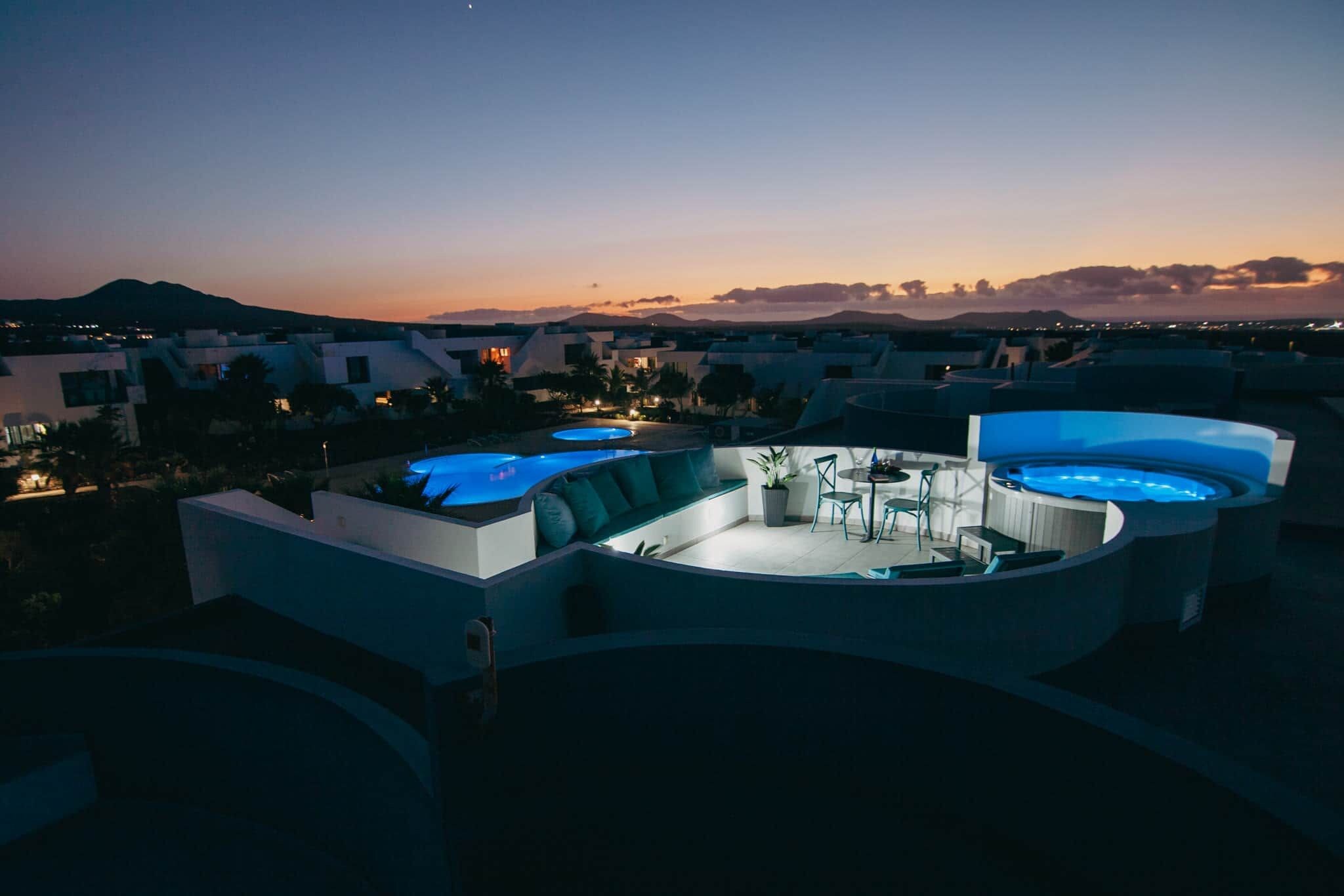 A rooftop terrace with a swimming pool, seating area, and a hot tub.