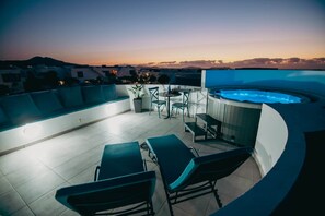 Eine Dachterrasse mit Swimmingpool, Liegestühlen und einem Tisch.