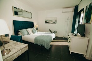 A hotel room with a bed, bedside table, lamp, dresser, and a painting on the wall. - Luxury Penthouse: Terrace, Hot Tub and Sauna (La Oliva)