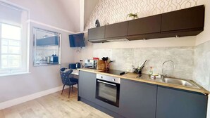 Una cocina moderna con horno integrado, un lavabo y una ventana con vistas a la ciudad.