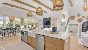 Una cocina amplia con vigas de madera, ventanas grandes y una isla central.