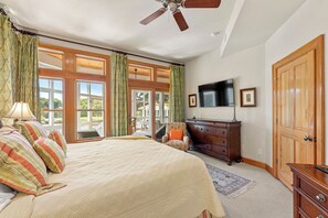 Relax in this serene bedroom with a large bed, dresser, and TV.