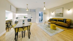 A modern apartment with a kitchen, dining area, and living room. - One Bedroom Apartment Close to MOD (Bristol)