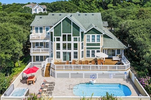 A large two-story house with a swimming pool, outdoor seating, and a deck. - Private Pool | Hot Tub | Rec Room | Dogs OK (Corolla)