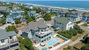 A coastal residential area with houses featuring balconies and a swimming pool. - Payson Place: Oceanside, Pool, Golf Discounts, Spa (Corolla)