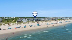 Een strand met huizen en een aanduiding voor Village Realty.