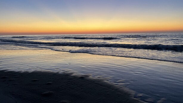 A beach at sunset with waves gently lapping at the shore. - Gorgeous 2 Bedroom Condo - Pool/Tiki Bar/Beach (Hilton Head Island)