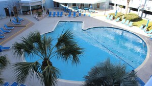A large outdoor swimming pool with blue lounge chairs and palm trees. - Gorgeous 2 Bedroom Condo - Pool/Tiki Bar/Beach (Hilton Head Island)