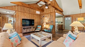 Un salon spacieux avec un décor intérieur en bois, une télévision et des sièges confortables.