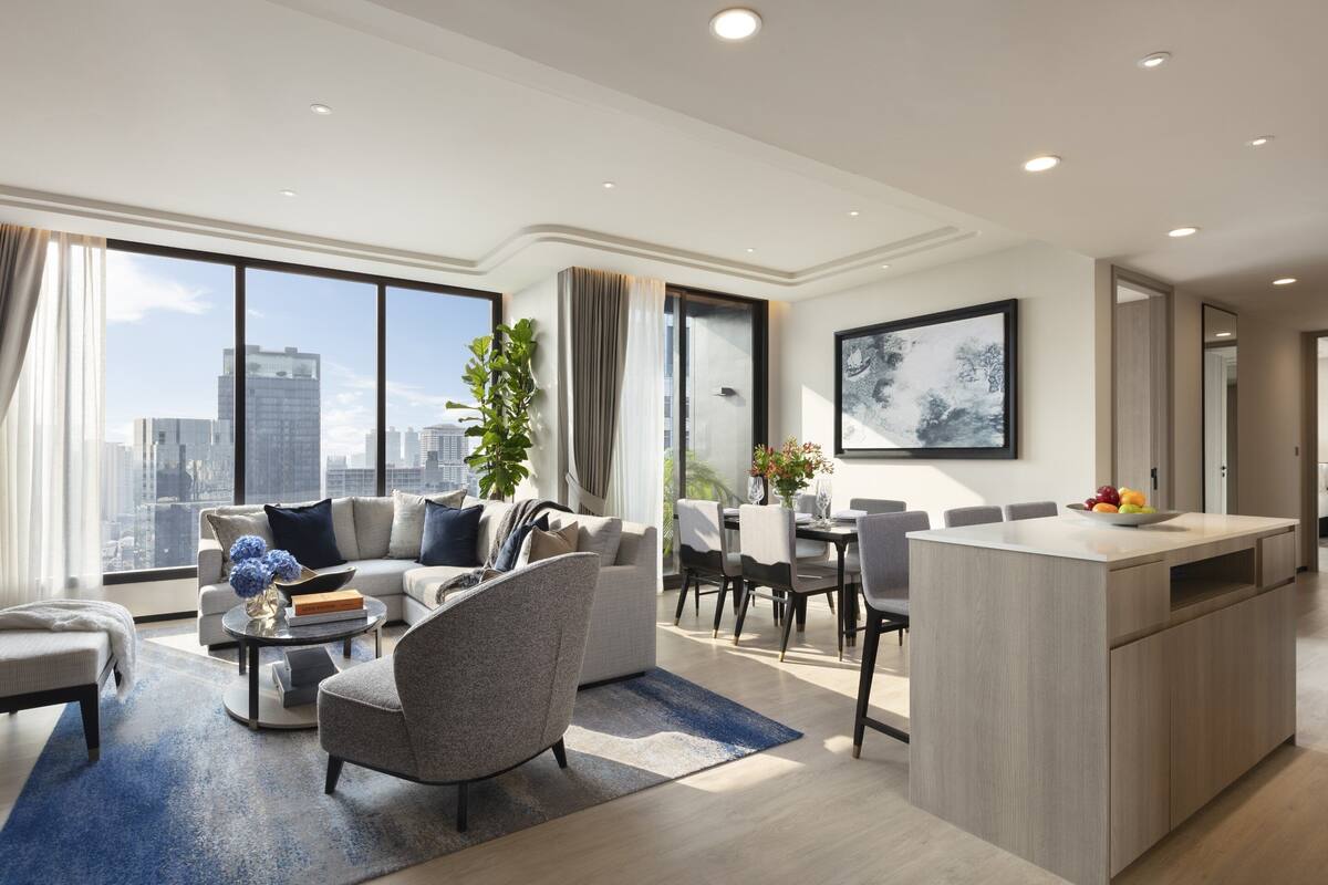 A modern living room with a sofa, coffee table, and dining area.