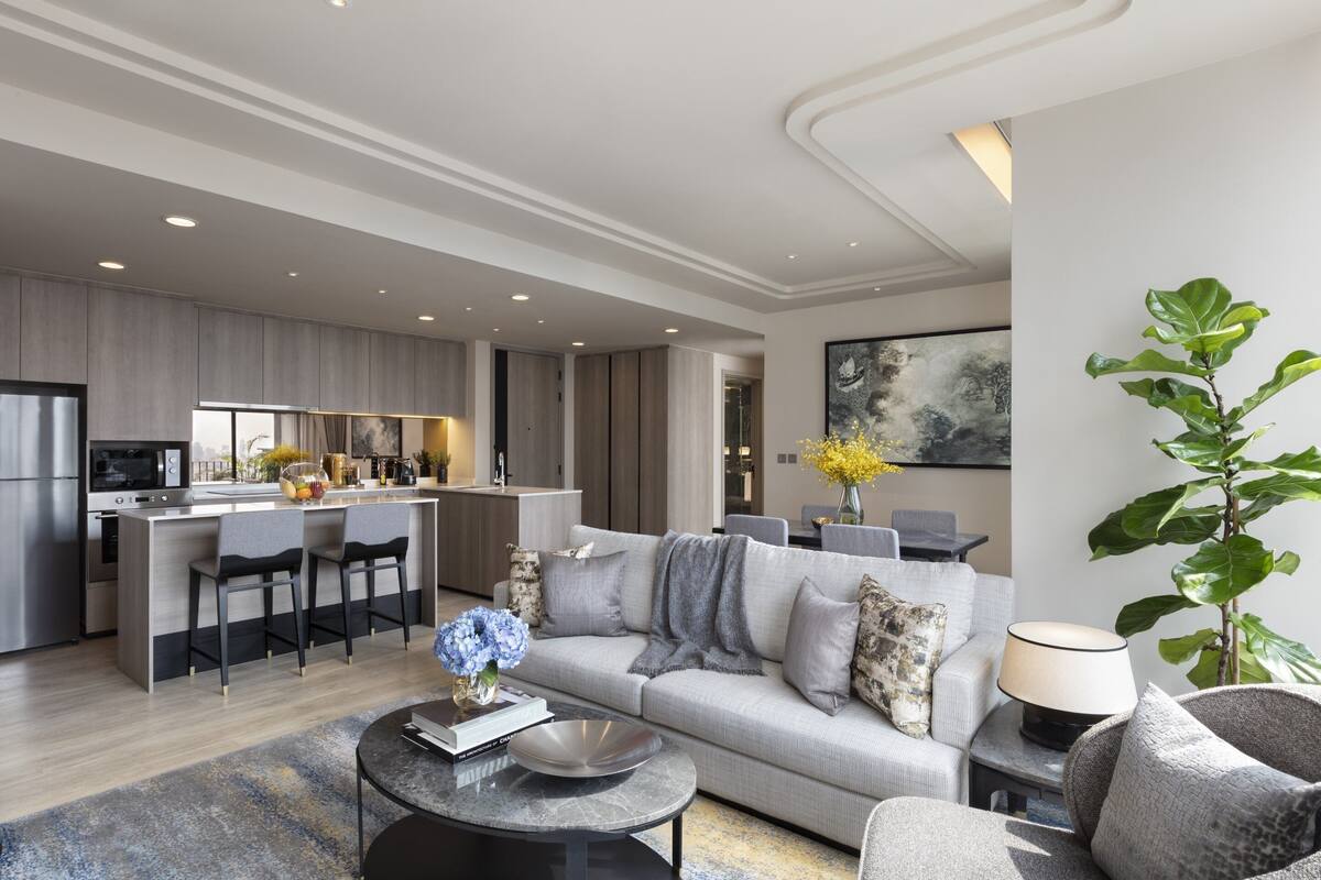 A modern living room with a sofa, coffee table, and a dining area with chairs.