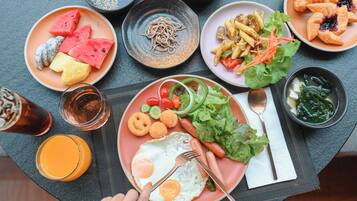 A table with various dishes including a plate with an egg, vegetables, and a croissant.