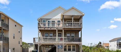 A multi-story building with a balcony on the second floor, a covered entrance, and a sign indicating a Village Inn.