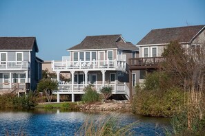 A waterfront property with multiple houses featuring balconies and a small dock.