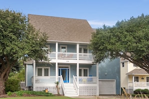 A two-story house with a blue exterior, white railings, and a blue front door. - Moon Over Magnolia: Private Pool, Spa, Rec Room (Corolla)