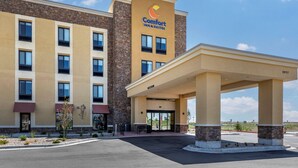 A Comfort Inn & Suites building with a stone facade, multiple windows, and a covered entrance area.