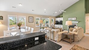A spacious living area with a kitchen, dining table, and seating. - Birdie: Private pool, Spa, Golf discounts (Corolla)