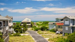 A coastal residential area with houses, a paved road, and the ocean in the background. - Fish Tank: Oceanside, Private Pool, Hot Tub, close to beach & golf discounts! (Corolla)
