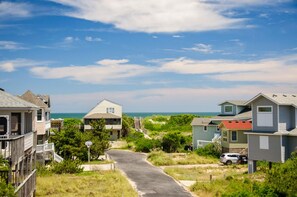 A coastal residential area with houses, a paved road, and the ocean in the background. - Fish Tank: Oceanside, Private Pool, Hot Tub, close to beach & golf discounts! (Corolla)