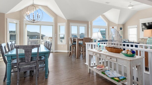 A spacious dining area with a high ceiling, large windows, and a view of the surrounding landscape. - Fish Tank: Oceanside, Private Pool, Hot Tub, close to beach & golf discounts! (Corolla)