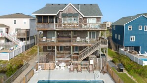 A multi-story residential building with a pool, outdoor seating, and a deck. - Salt Shaker: Semi-oceanfront, Private Pool, Spa (Nags Head)