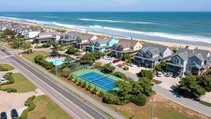 A coastal residential area with houses, a tennis court, and a pool. - Sea-Duced: Oceanfront, Great Views, Shared Pool. (Nags Head)