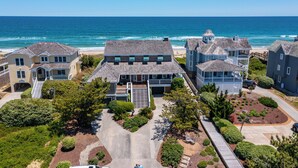 A coastal residential area with houses, a beach, and a clear view of the ocean.