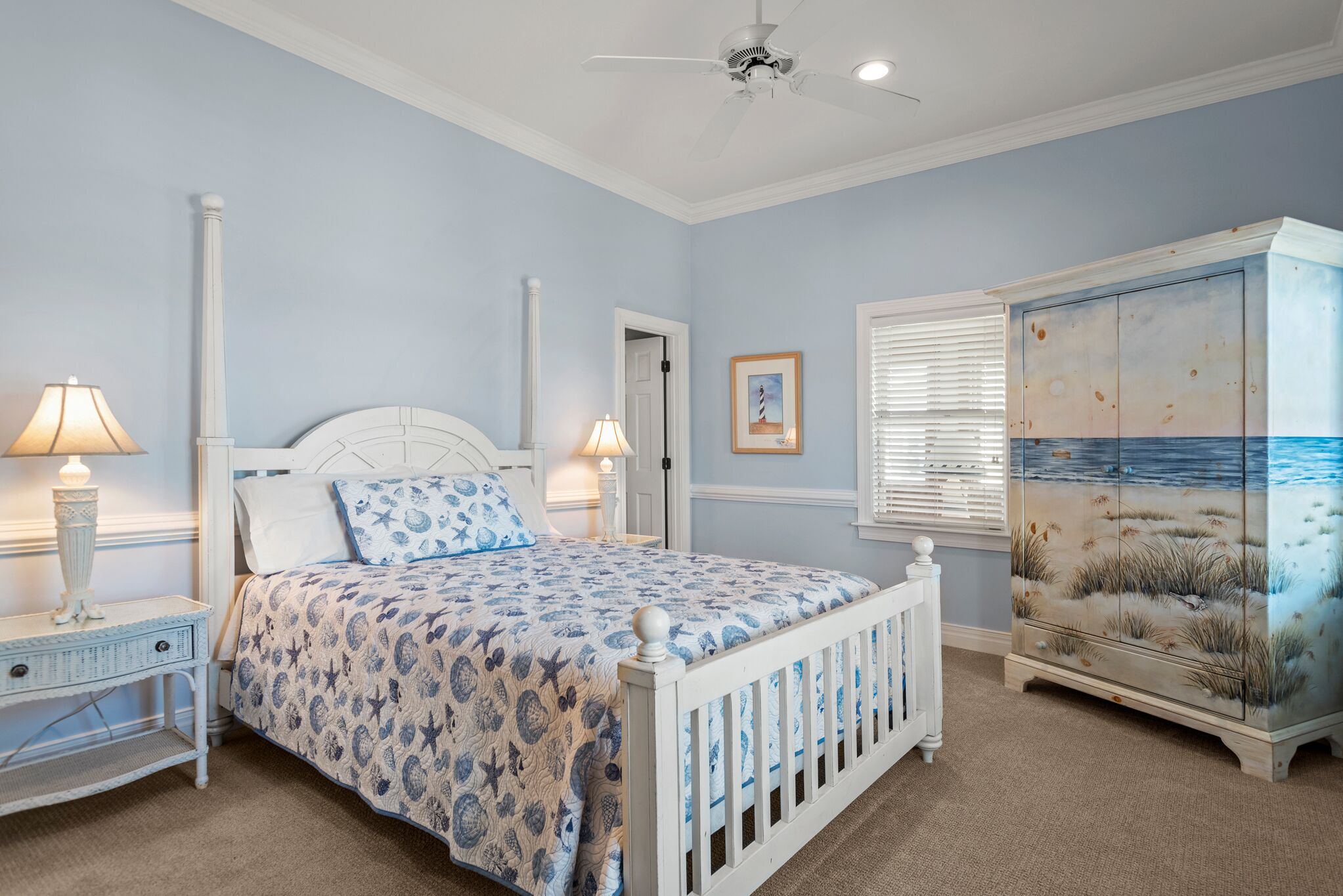 A bedroom with a bed, nightstands, a dresser, and a ceiling fan.