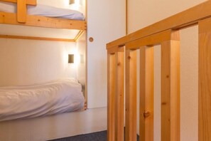 Ein Zimmer mit einem Etagenbett und einer Holztür.