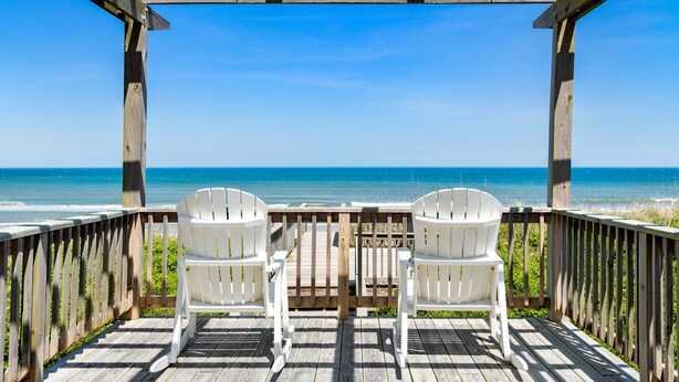 A wooden deck with two white Adirondack chairs facing a beach. - Favorite Place: Oceanfront, Private Pool, Spa (Nags Head)