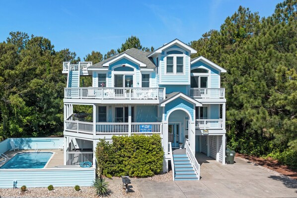 A two-story house with a pool, a balcony, and a staircase leading to the upper level.