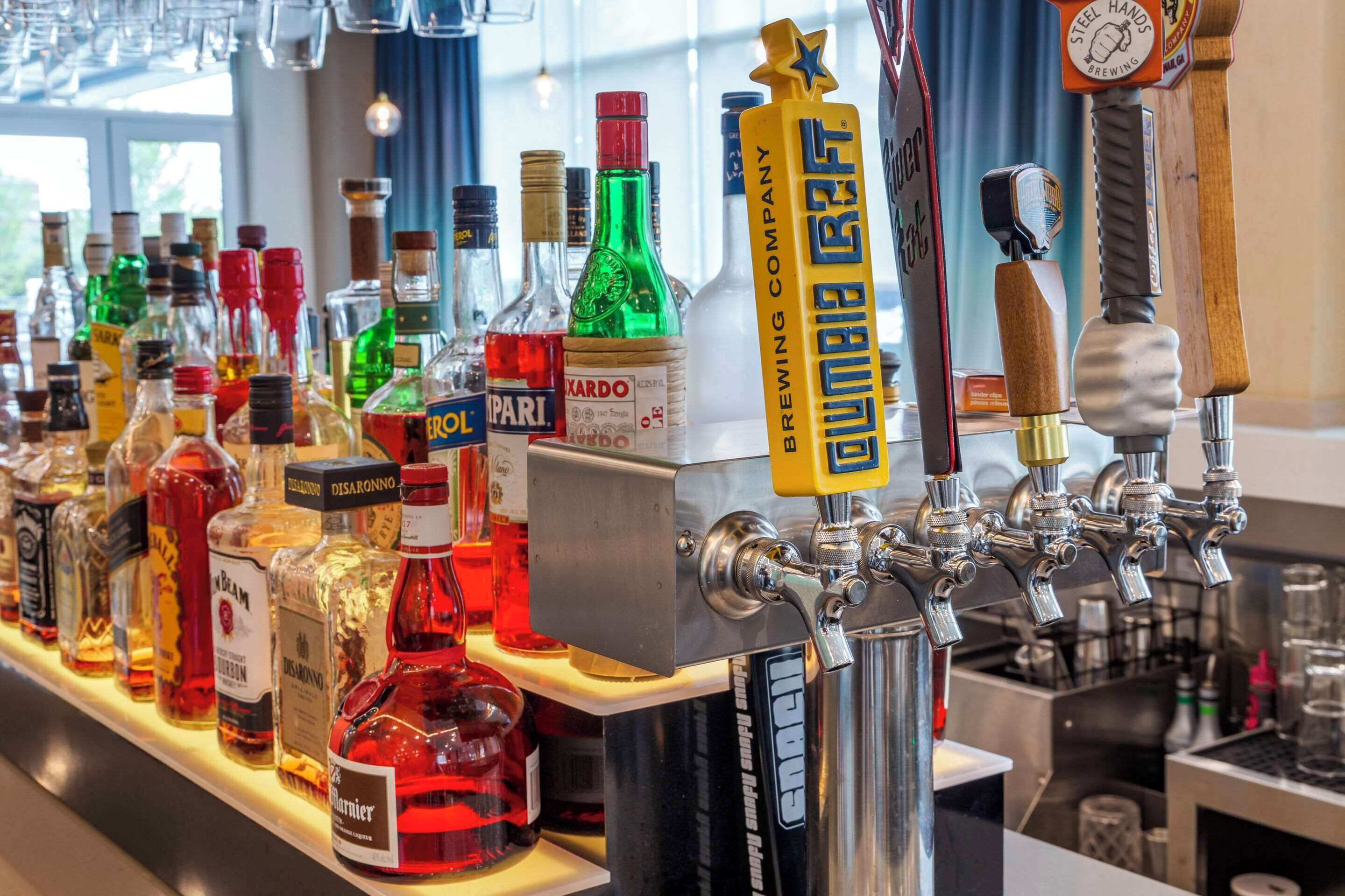 A bar with multiple liquor bottles and a tap labeled "Steel Hands Brewing Company."