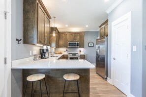 Una cocina moderna con una isla grande, electrodomésticos de acero inoxidable y armarios de madera.