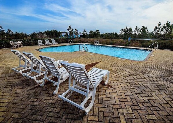 A pool area with lounge chairs and a brick patio. - Great Cottage~Perfect Destination for an amazing Vacation!!! (Gulf Shores)