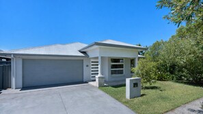 Ein eingeschossiges Haus mit Garage, einer kleinen Veranda und einem gepflegten Rasen.