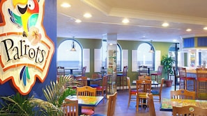Guests can dine with a view of the sea from the restaurant's tables and chairs, surrounded by a vibrant mural.