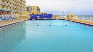 Relax by the rectangular pool surrounded by a deck and lounge chairs.