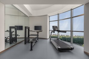 A modern gym with a treadmill, weight machines, and a TV. - Holiday Inn Express Changchun Ecological Square by IHG (Changchun)