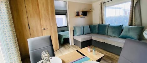 Ein modernes Wohnzimmer mit einer Couch, Sesseln, einem Esstisch und Blick auf die Stadt.