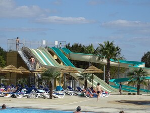 Un parc aquatique doté de plusieurs toboggans, de chaises longues et d’une piscine.