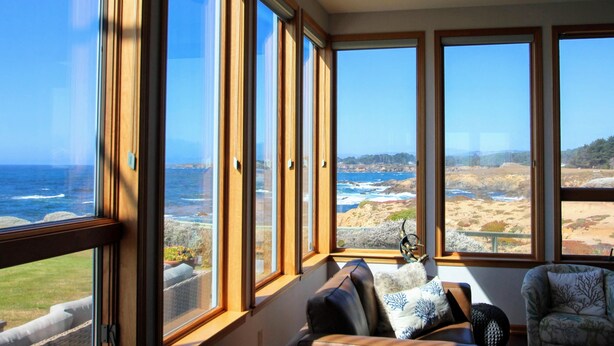 A room with large windows offering a coastal view.