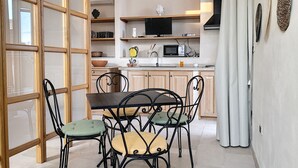 Une cuisine compacte comprenant une table et des chaises, un four à micro-ondes et un évier.