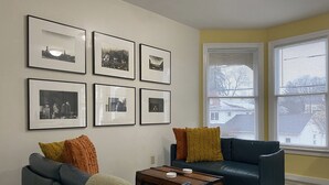 A living room with two sofas, a coffee table, and six framed pictures on the wall.