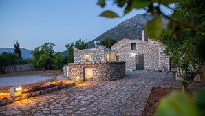Edifici de pedra amb un pati interior, parets de pedra i una muntanya al fons.