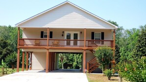 Une maison à deux étages avec un balcon, un garage et une véranda à l’avant.