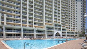 Ein großes Hotel mit mehreren Balkonen und einem zentral gelegenen Poolbereich.