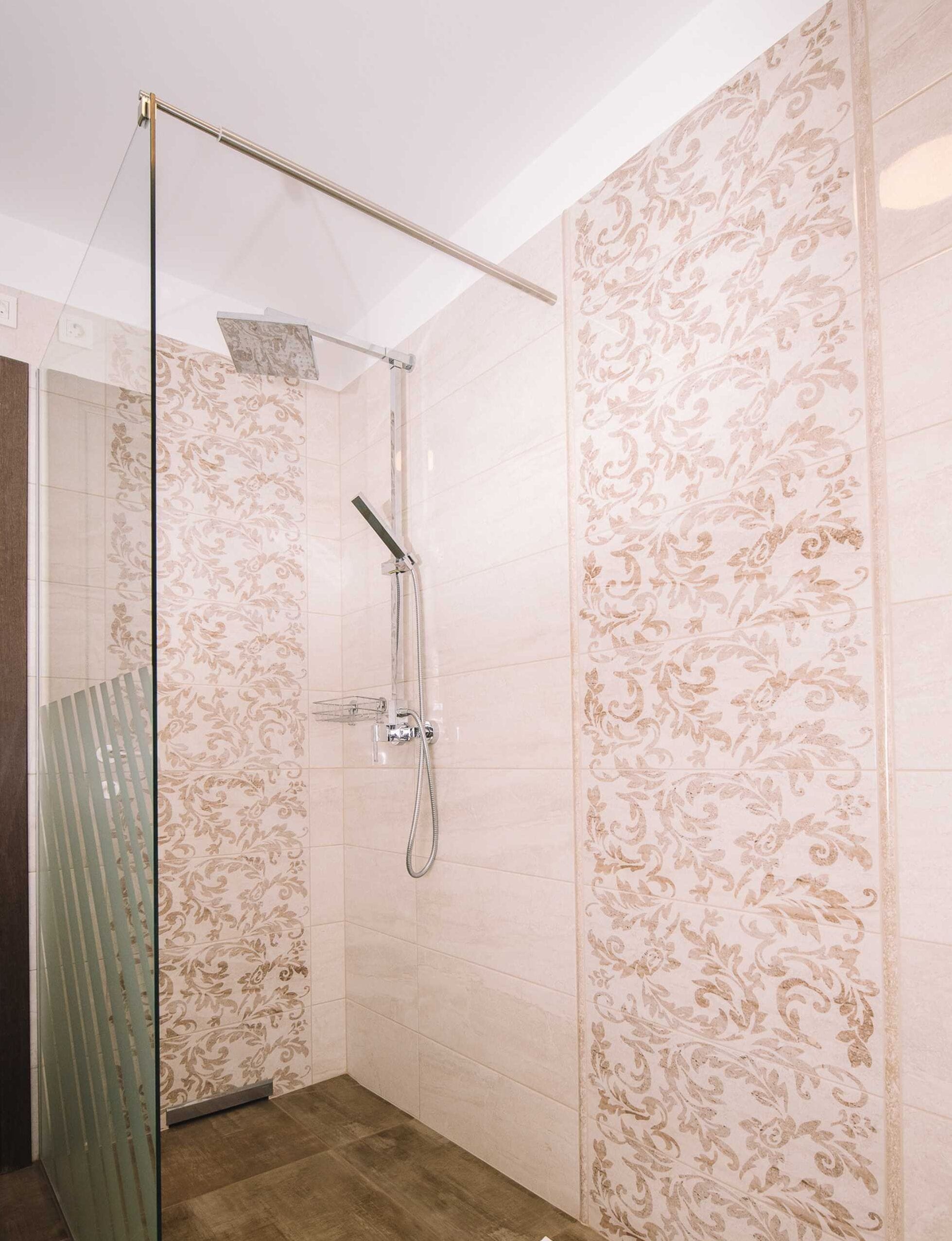 Eine moderne Dusche mit Glastür, Handbrause und fest installierter Bedienpanel.