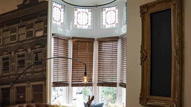 A room with a large bay window, a tufted armchair, a table with a red tablecloth, and a unique geometric pendant light. - Inviting 2-bed Apartment in Matlock Sleeps 6 (Matlock)